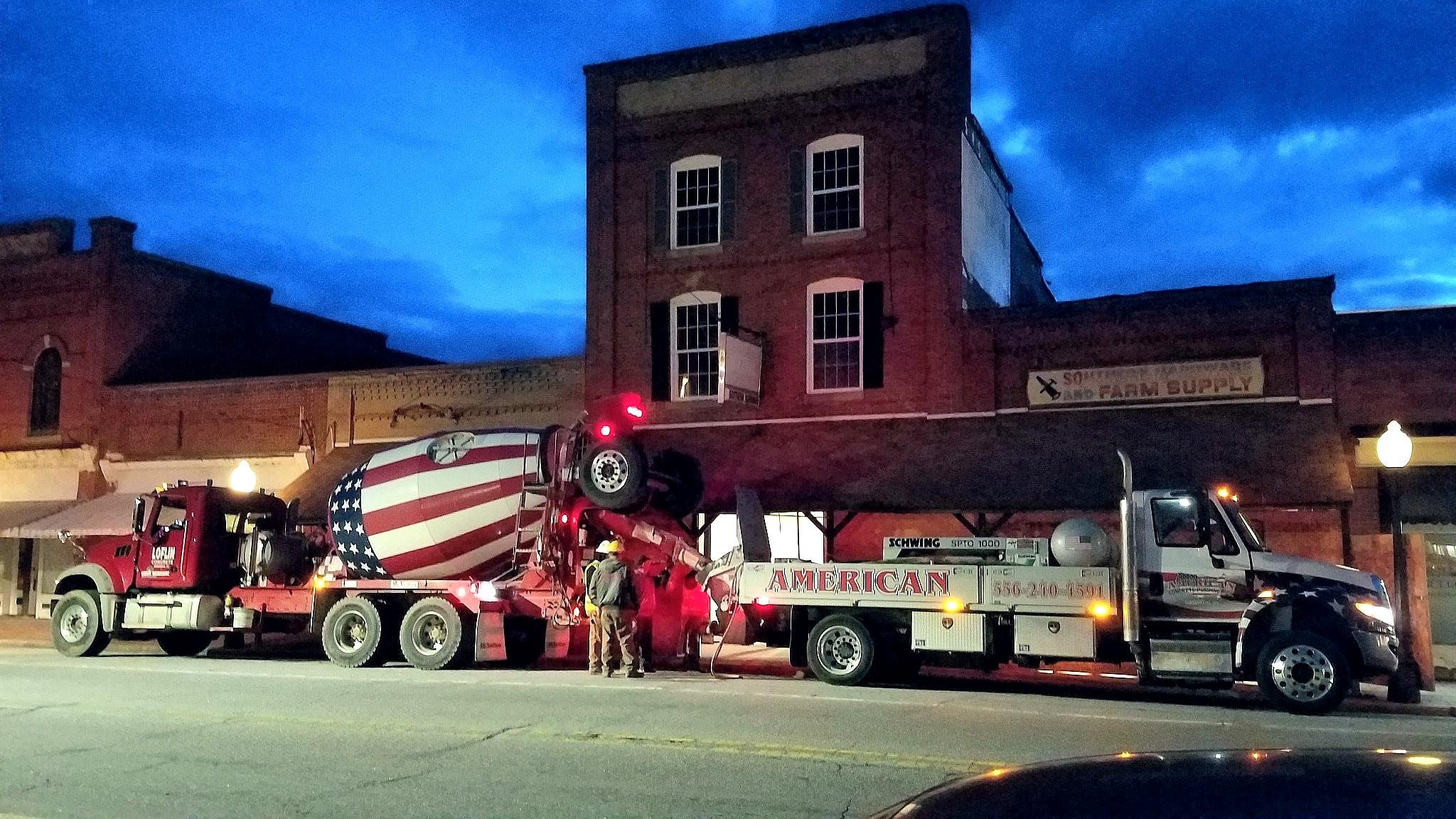 American-flag concrete mixer and pump truck outside Southern Hardware during restoration